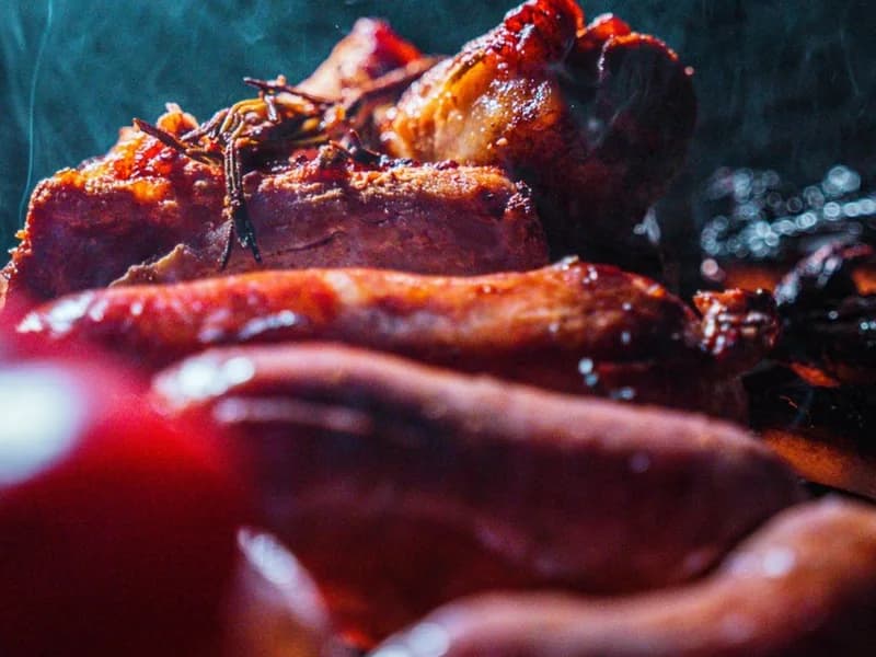 Carne alla brace fotografata nel fumo, in un locale